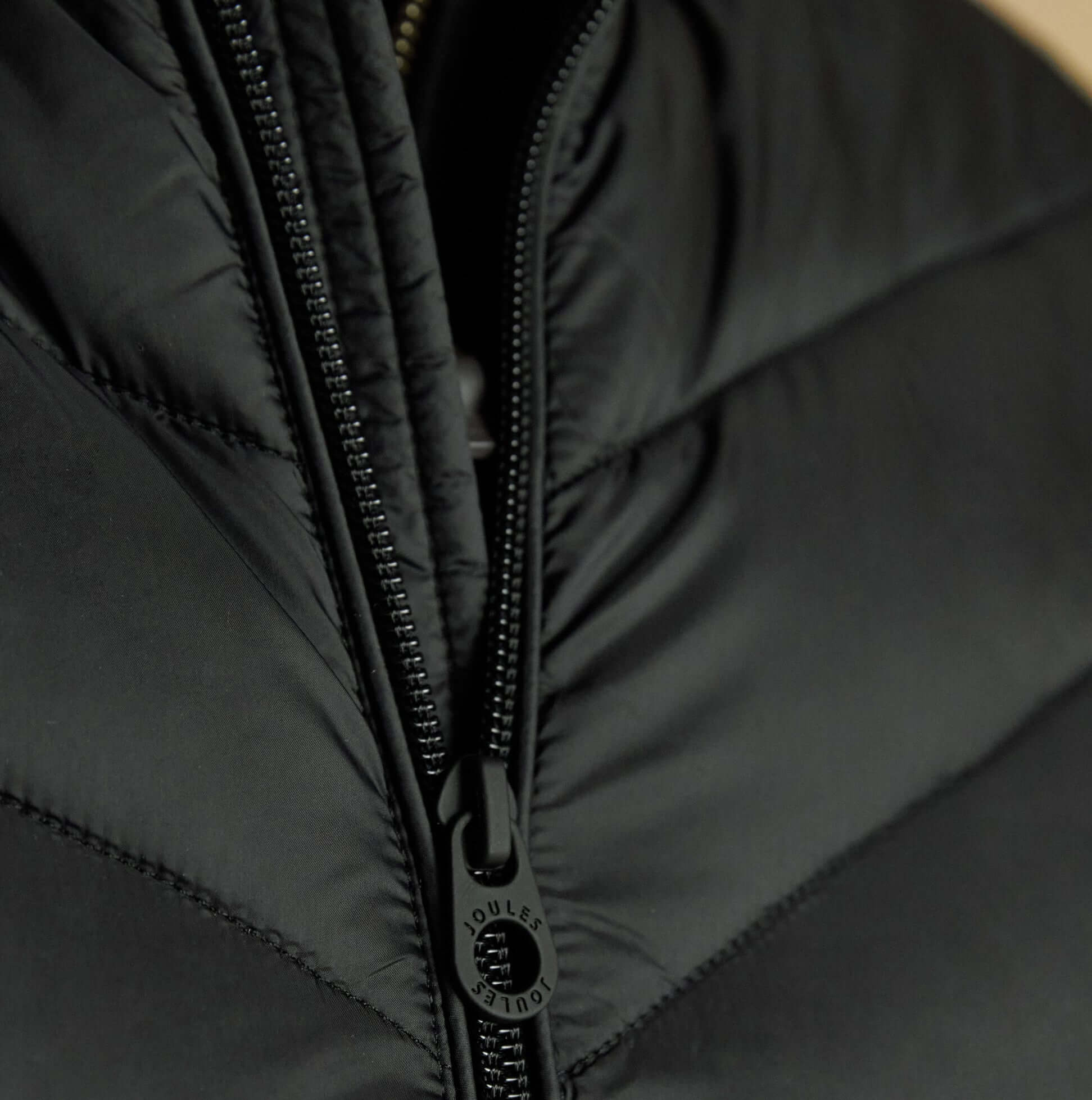 Joules GARRETT Mens Showerproof Padded Gilet Black close-up view of zip and fabric texture.