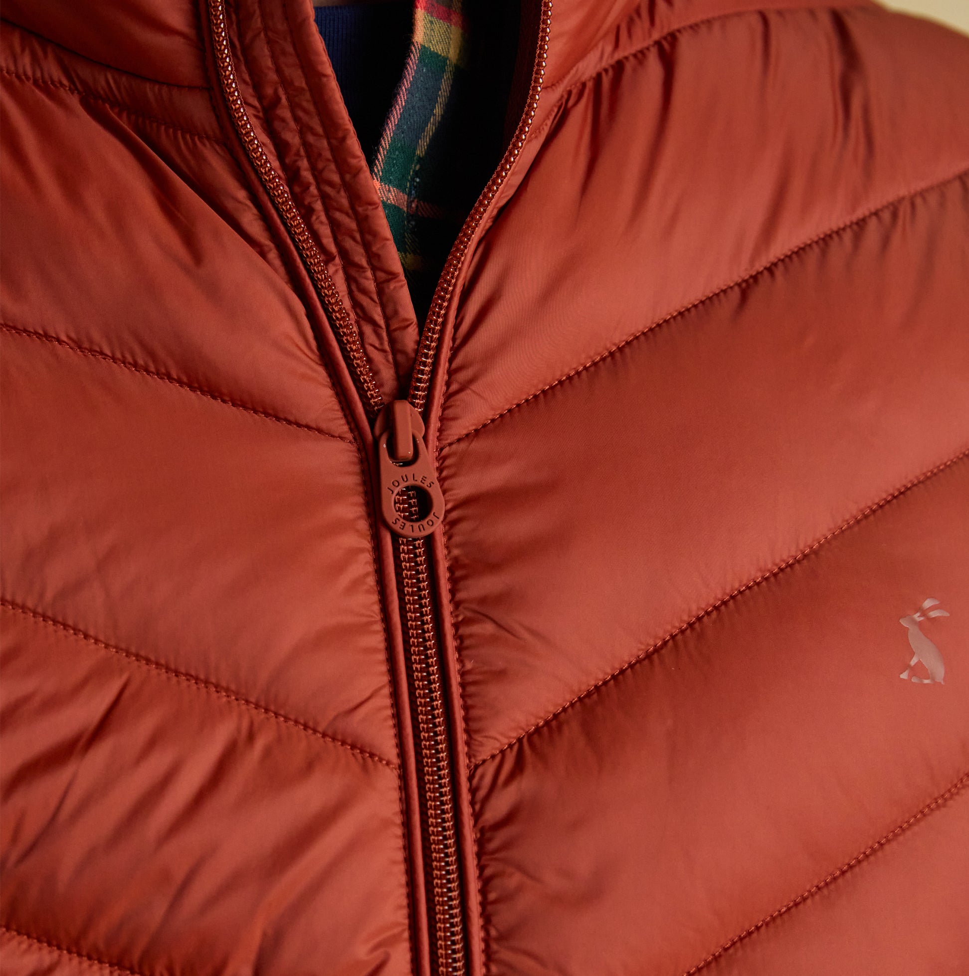 Joules GARRETT Mens Showerproof Padded Gilet Orange detail view, showcasing zipper and chevron pattern.