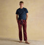 Joules DOZER Mens Pyjama Trousers Burgundy Red front view with a model wearing a navy top and burgundy patterned trousers.