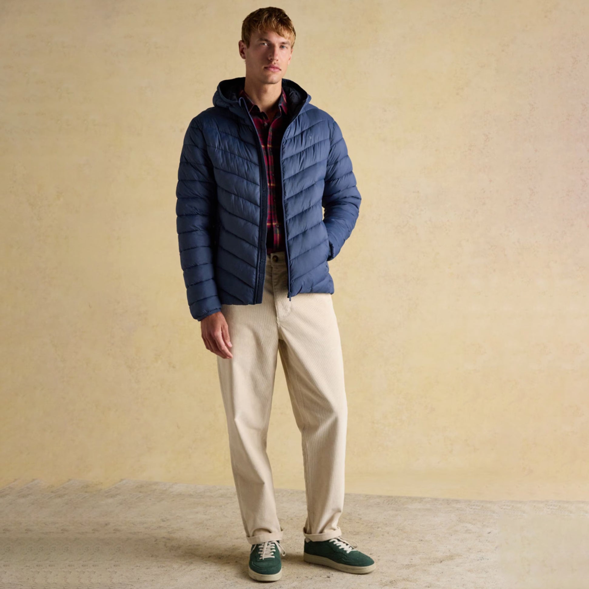 Joules Garrett Blue Showerproof Padded Jacket front view worn by model with beige pants and green shoes.
