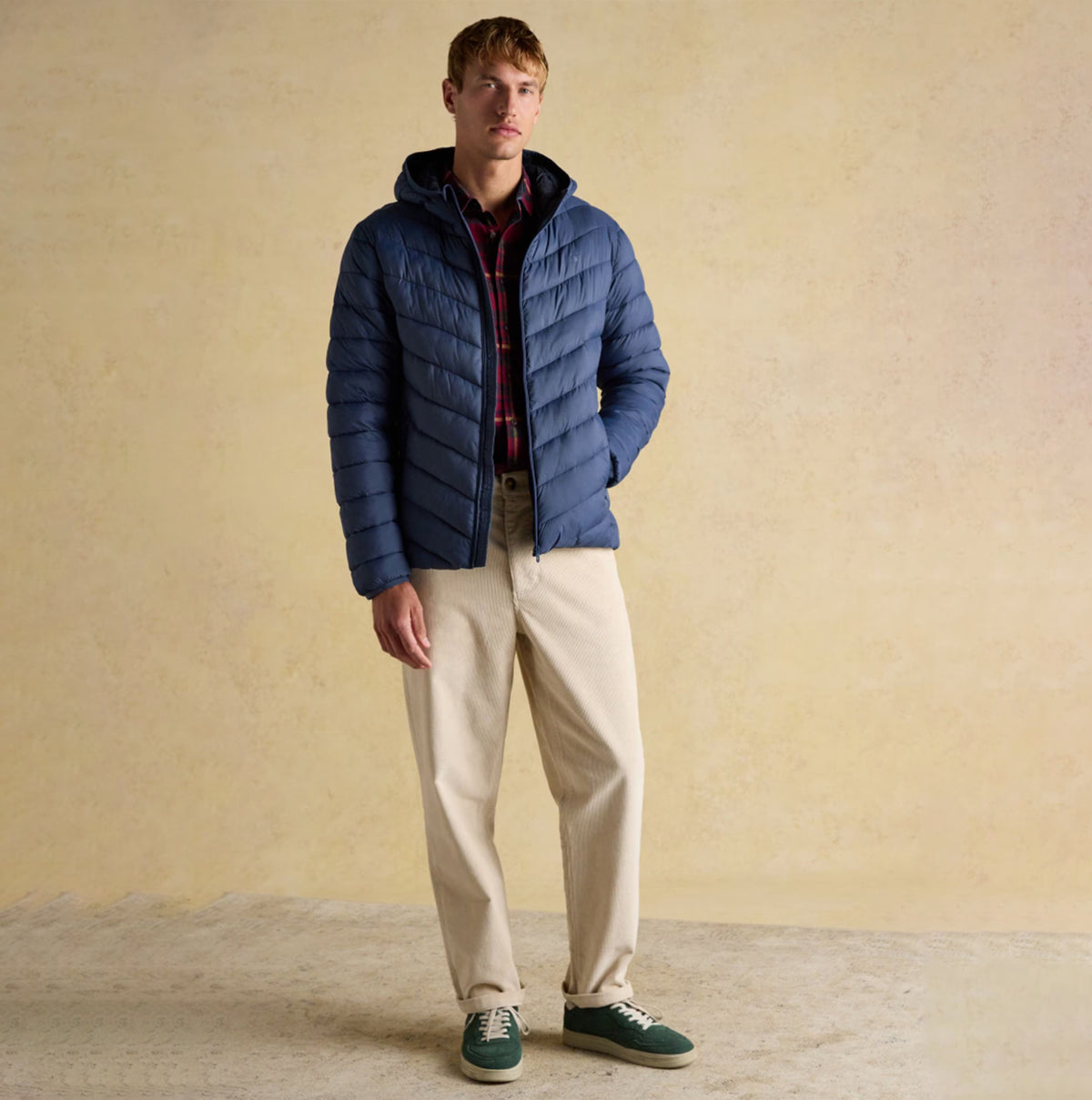 Joules Garrett Blue Showerproof Padded Jacket front view on model with beige trousers and green shoes.