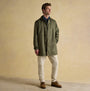 Joules SANDFORD Mens Waterproof Raincoat Green front view, featuring buttons and zip closure by model in a casual outfit.