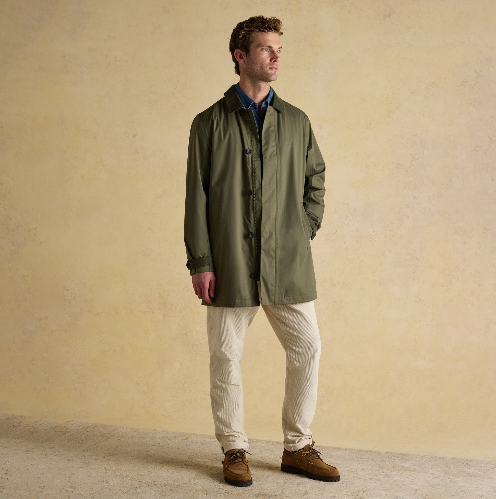 Joules SANDFORD Mens Waterproof Raincoat Green front view, featuring buttons and zip closure by model in a casual outfit.
