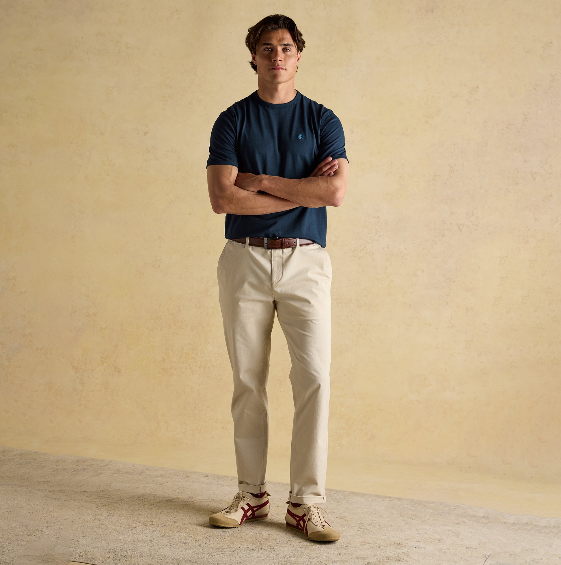 Joules RUGBY CLUB TEE Mens T-Shirt Navy front view, model wearing with cream trousers and styled footwear.