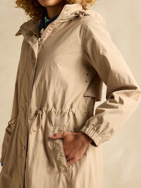 Joules Hensley Womens Waterproof Longline Coat with Packable Hood Tan Brown side view showcasing adjustable waist and pockets.