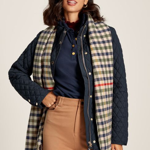 Joules LANGTREE Womens Scarf Henson Check detail view worn with a quilted jacket, showcasing the heritage check pattern and tasselled ends.