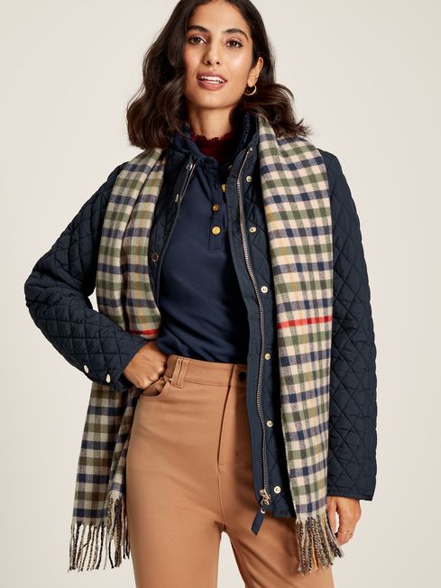 Joules LANGTREE Womens Scarf Henson Check detail view worn with a quilted jacket, showcasing the heritage check pattern and tasselled ends.