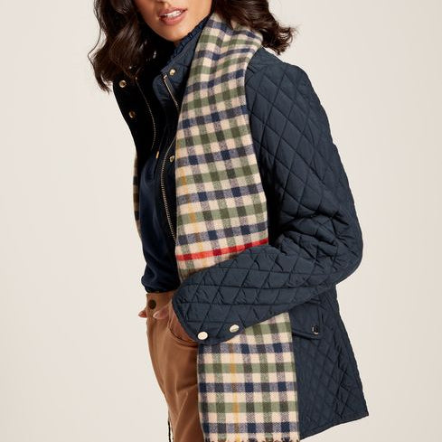 Joules LANGTREE Womens Scarf Henson Check styled with a navy quilted jacket, showcasing the heritage check pattern and tasselled ends.