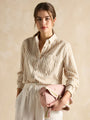 Joules TRENT Womens Cross Body Bag Pale Pink held by a model wearing a striped shirt, front view with a soft background.