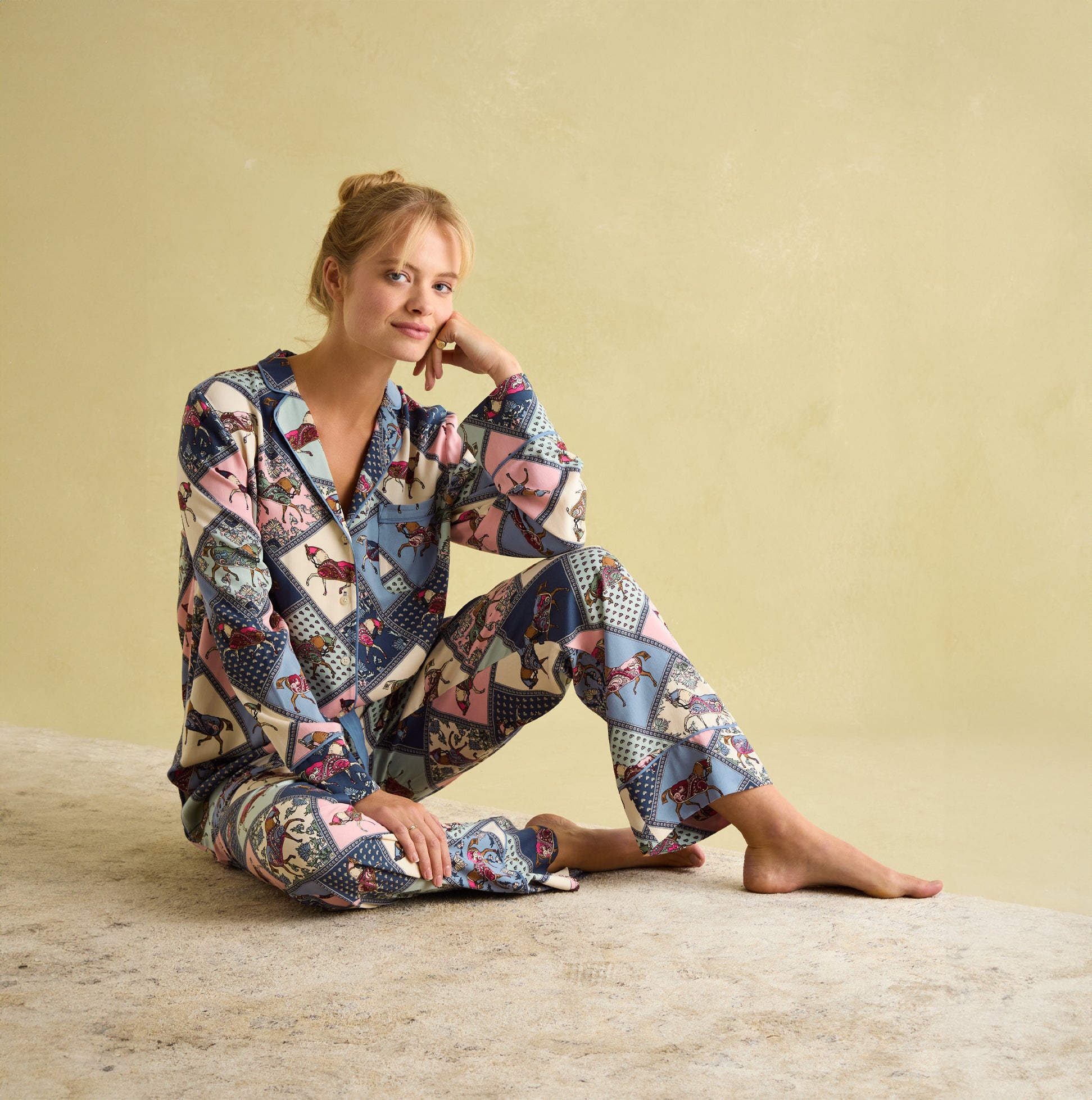 Joules ALMA Womens Pyjama Set Horse Multi front view, model in colorful horse print pyjamas with long sleeves and slanted pockets.