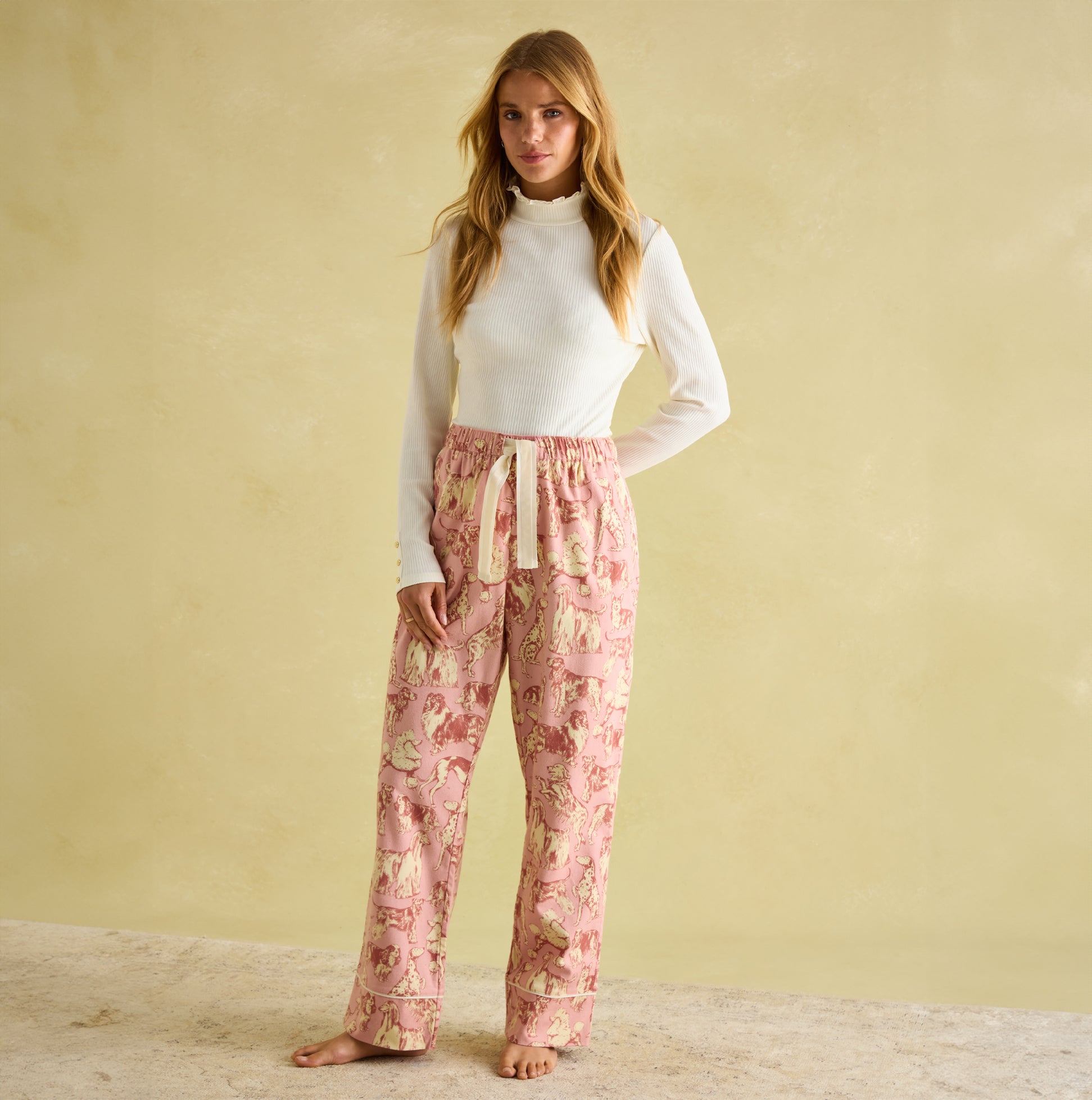 Joules STELLA Womens Pyjama Bottoms Pink Dogs front view on model, featuring a hand-drawn print and elasticated waist.