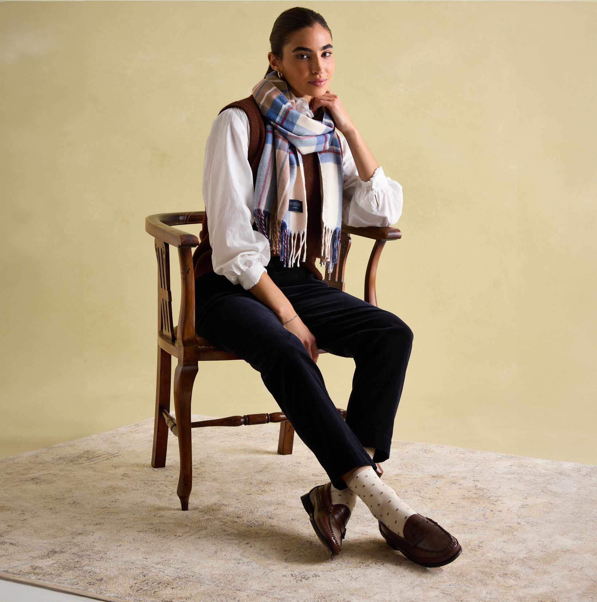 Joules LANGTREE Womens Scarf Cream Check, front view on model seated, showcasing checked pattern and tasselled ends.