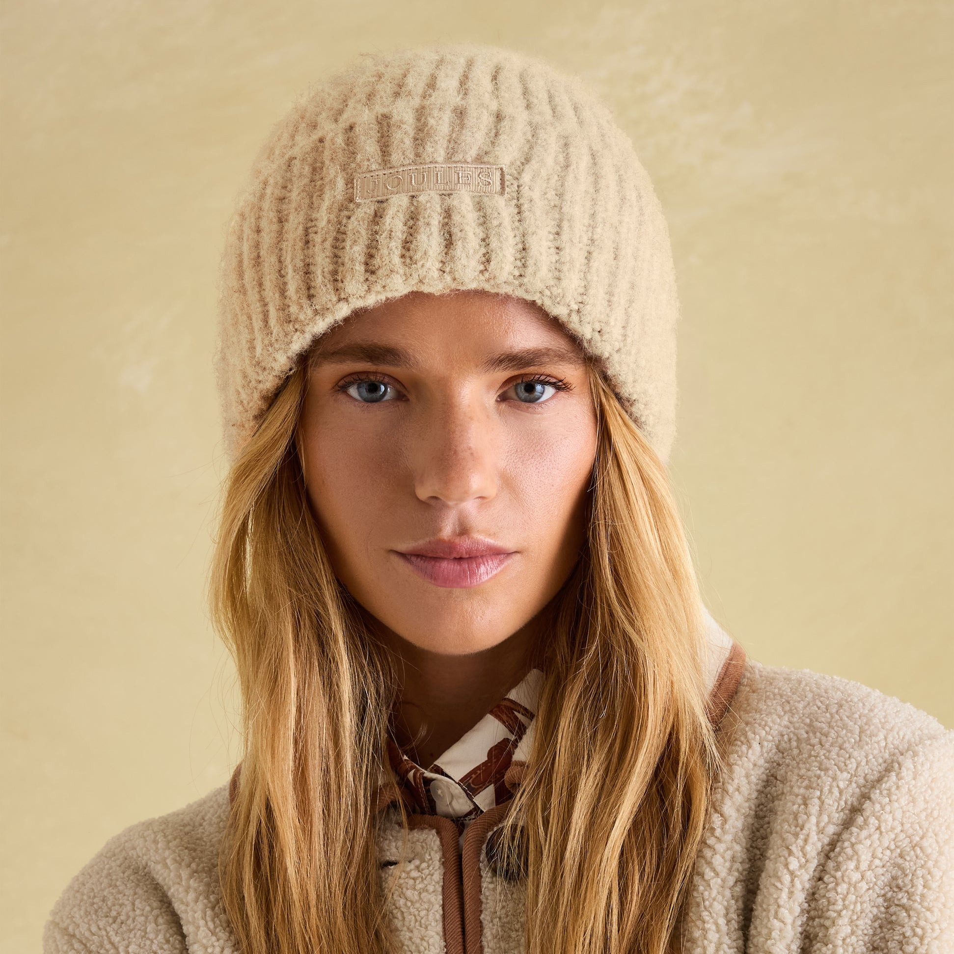 Joules CAVERSHAM Womens Beanie Oat front view, showcasing the stylish ribbed design and logo detail.