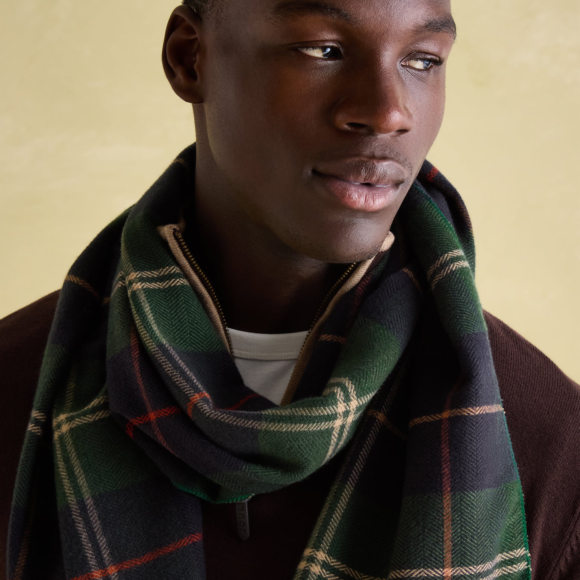 Joules MENS LANGTREE Mens Scarf Navy Check worn elegantly by a model, showcasing the checked pattern and tasselled ends.