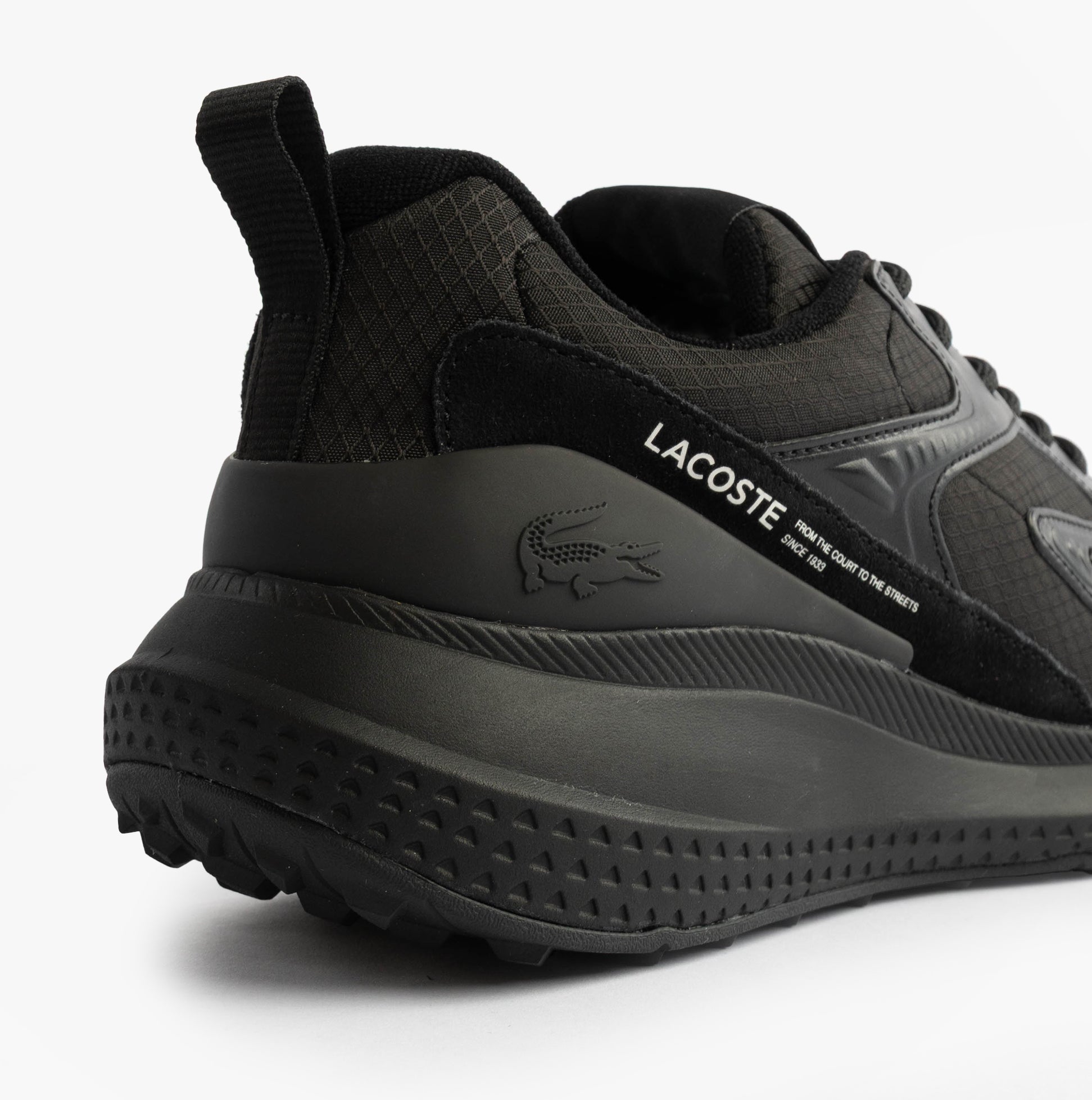 Lacoste L003 EVO Mens Performance Trainers Trainers Black side view showcasing breathable mesh upper and rubber sole.