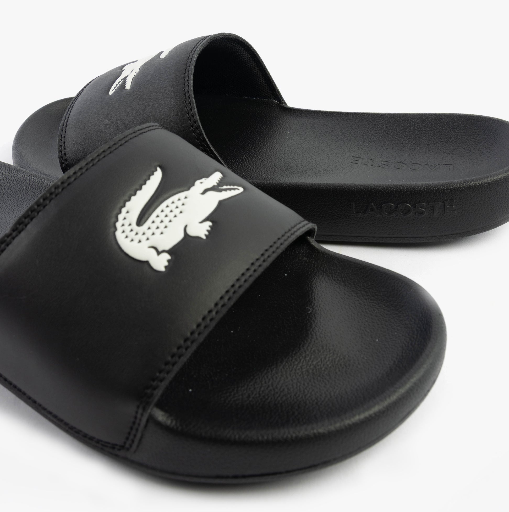 Lacoste SERVE SLIDE 0.0 Mens Slides Black/White side view showing EVA upper and iconic logo.