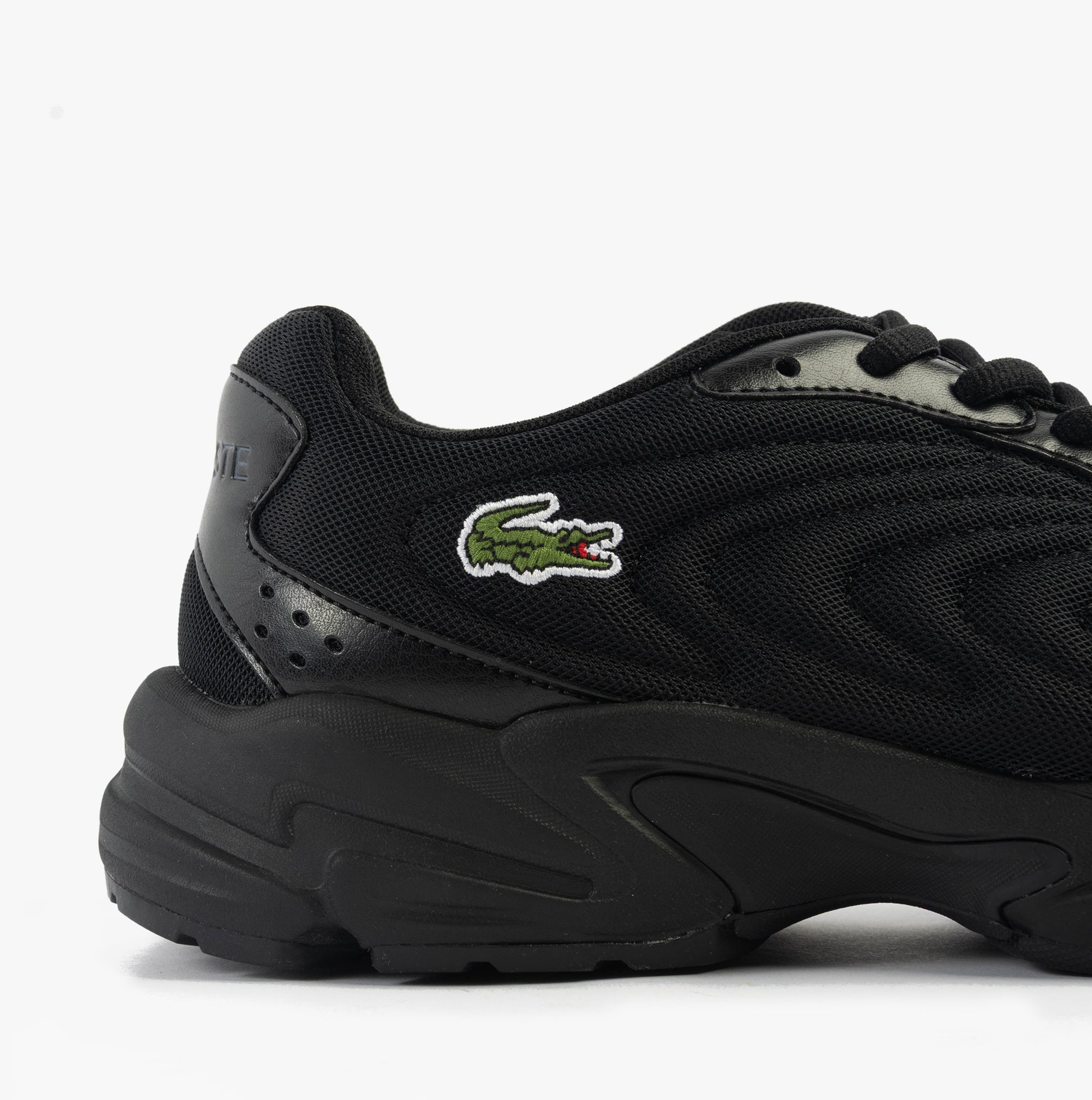 Lacoste STORM 96 2K LITE Mens Trainers Black side view showcasing black mesh and leather upper with brand logo.
