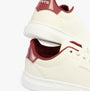 Levi's ELLIS 2.0 Womens Trainers Off White side view showcasing the round toe and lace-up closure with burgundy details.