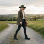 Mud Dogs BROOKE Womens Ankle Neoprene Wellies Black worn by a woman on a country road, showcasing a side view of the stylish boots.