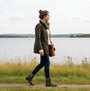 Mud Dogs BROOKE Womens Ankle Neoprene Wellies Dark Green worn by a woman walking by a lake in a side view.