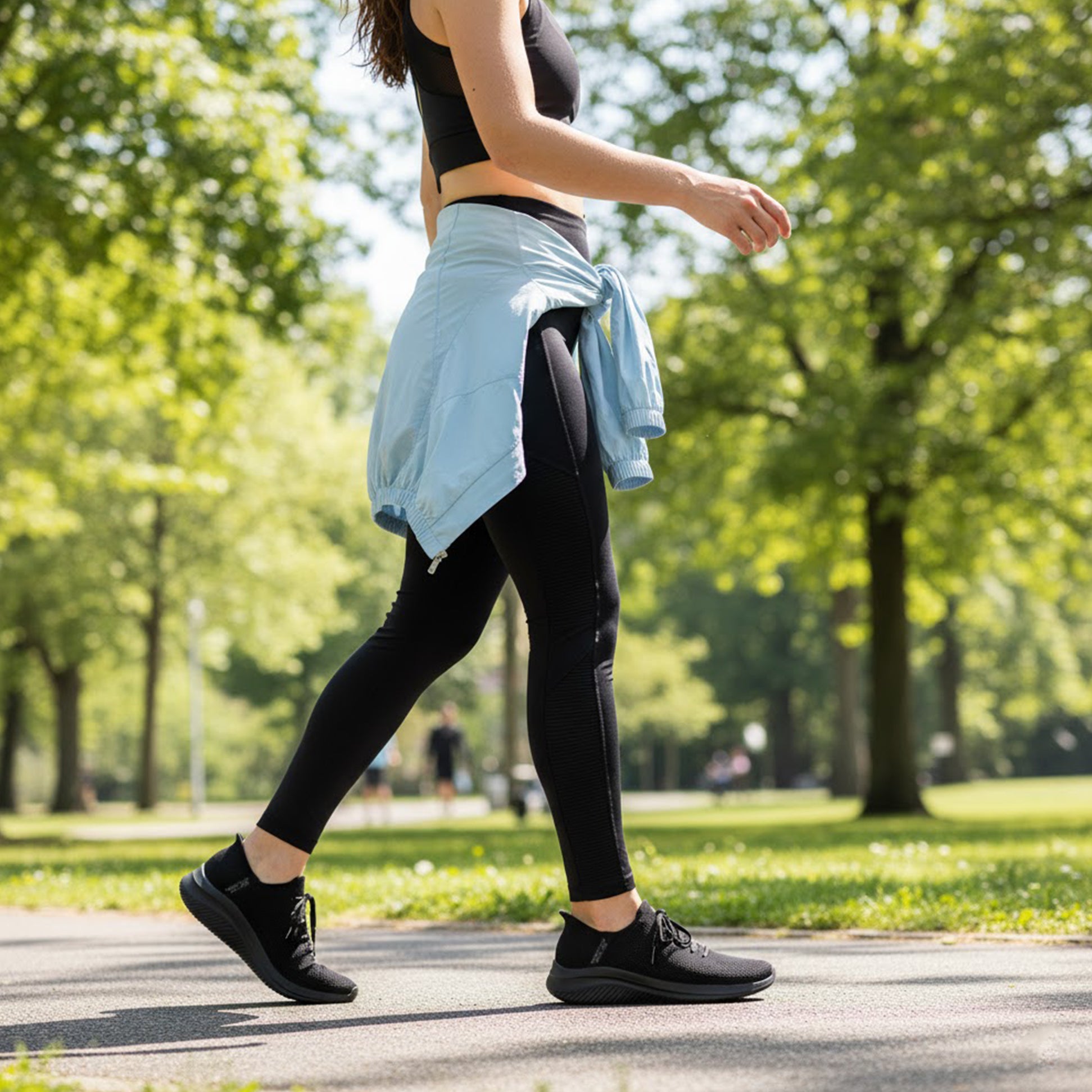 Skechers 150457/BBK ULTRA FLEX 3.0-ELEVATED MOTION Womens Trainers Black side view on a woman walking in a park.