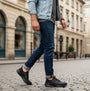 Skechers 210828/BBK SLADE - ZACHARY Mens Trainers Black side view worn with jeans on a street.