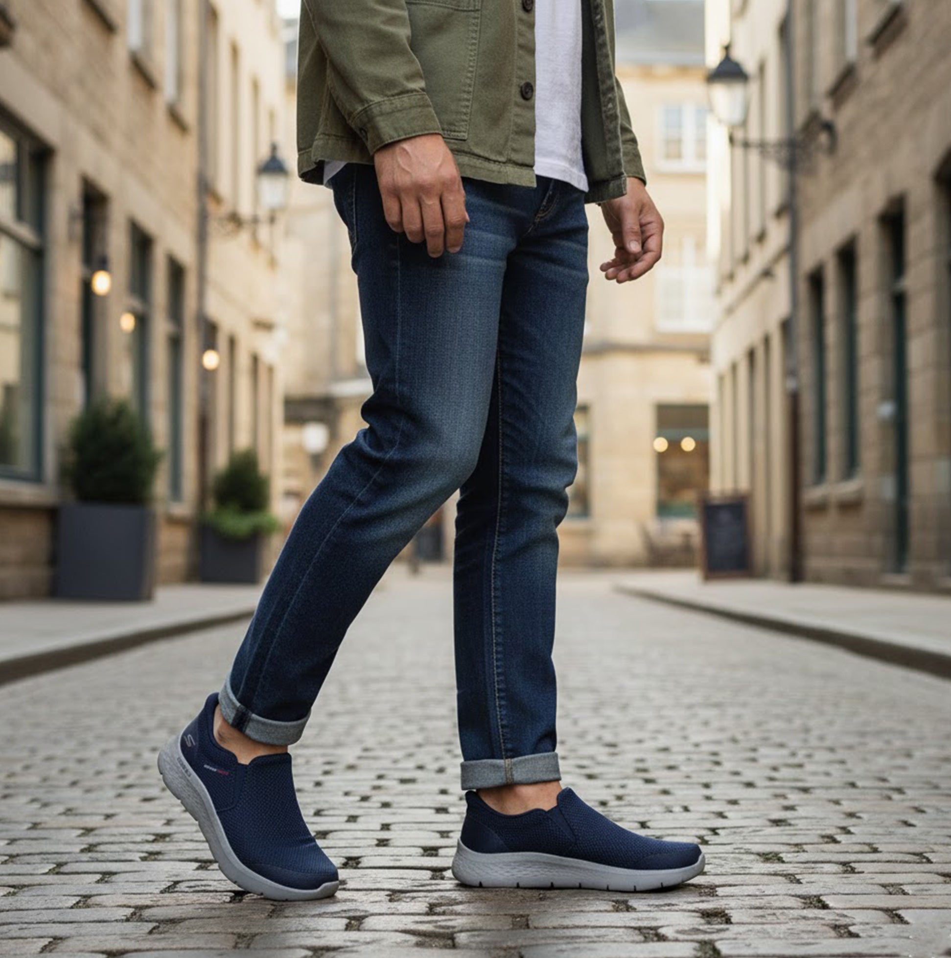 Skechers 216333/NVY GO WALK FLEX - OJAI Mens Trainers Navy side view worn by a man walking on cobblestone street.