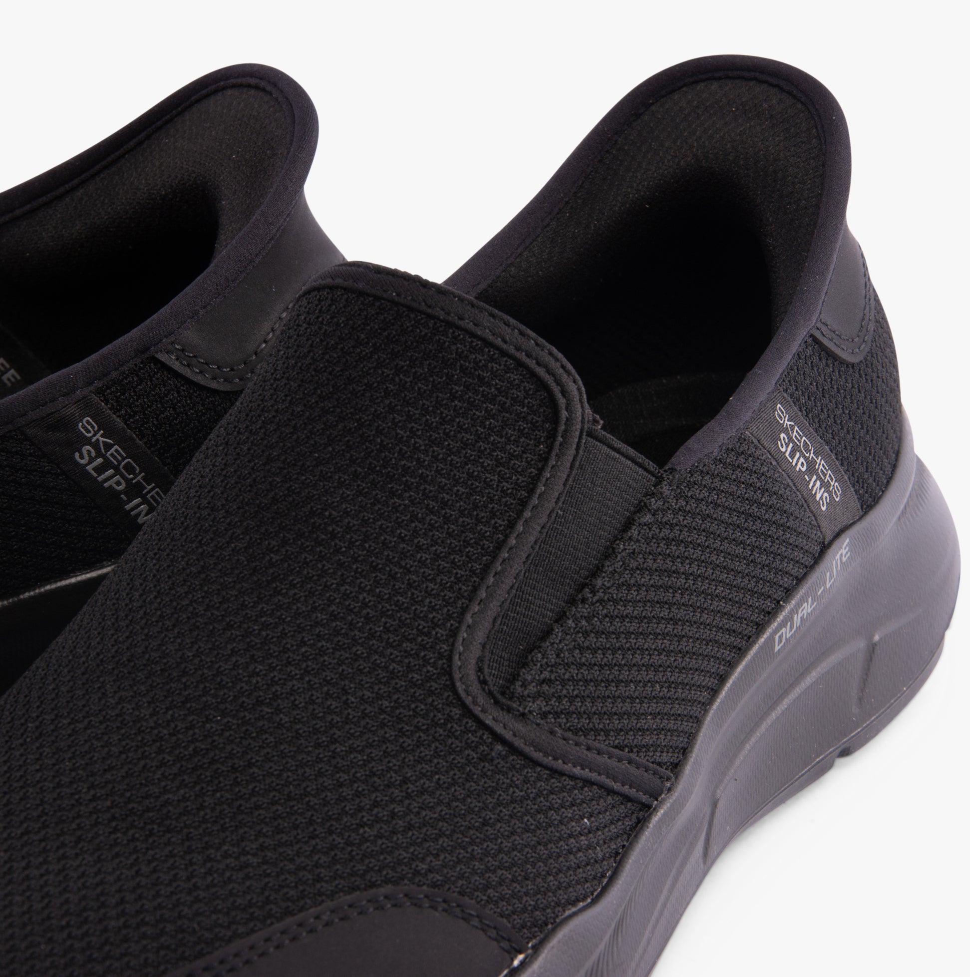 Skechers 232926/BBK EQUALIZER 5.0 - DRAYZE Mens Trainers Black close-up view showing slip-on design and textured upper.