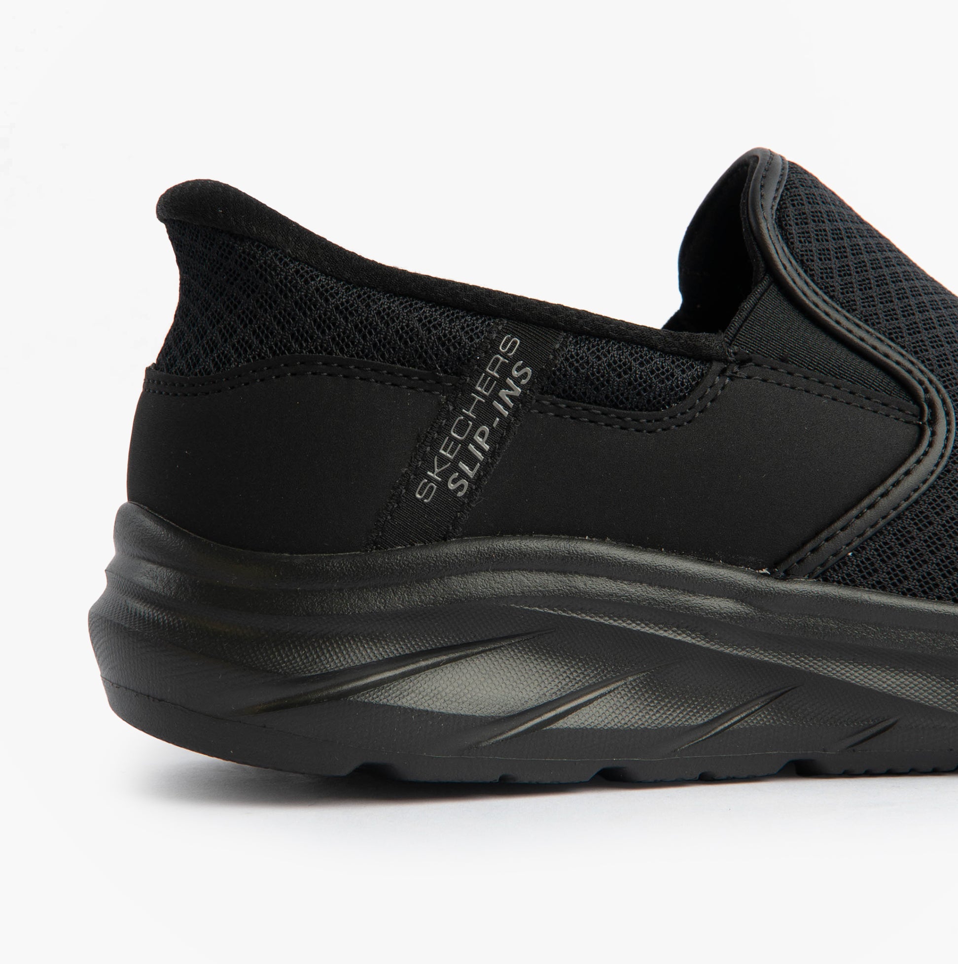 Skechers 233103/BBK EQUALIZER 6.0 - STOAVER Mens Trainers Black side view showcasing slip-on style and mesh upper.