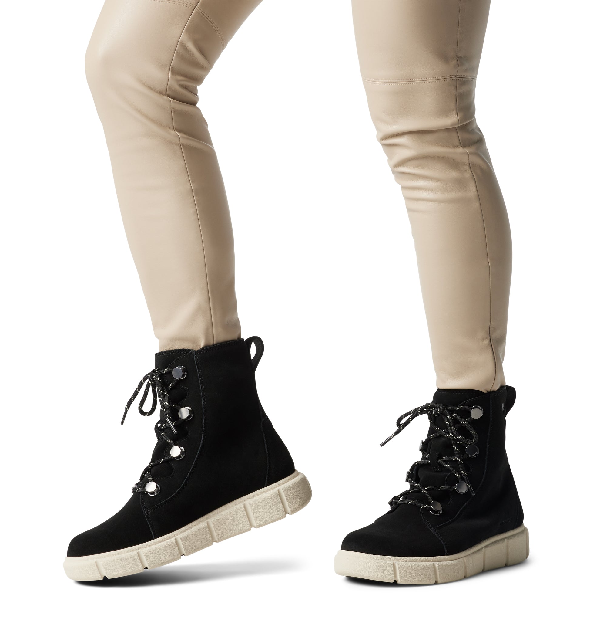 Sorel EXPLORER III JOAN Womens Winter Boots Black side view on model wearing fitted pants.
