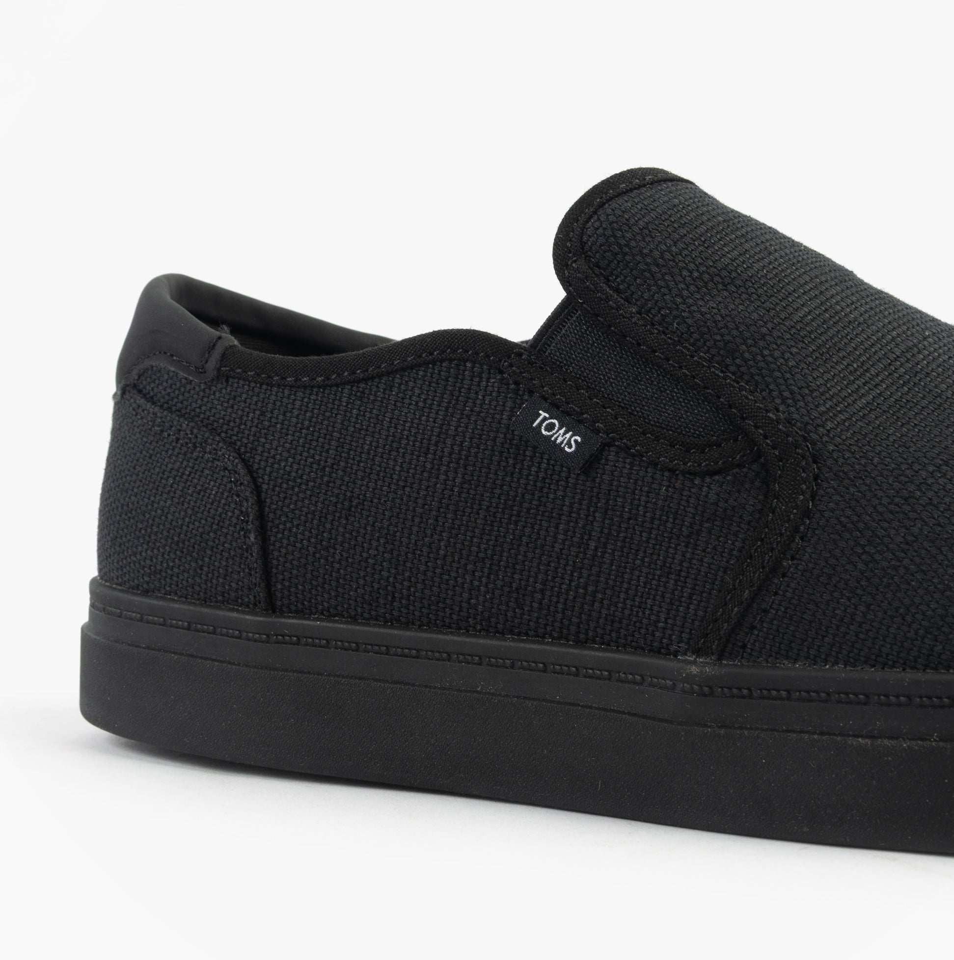 Side view of TOMS BAJA 2.0 Mens Casual Canvas Trainers Black showcasing canvas upper and slip-on design.