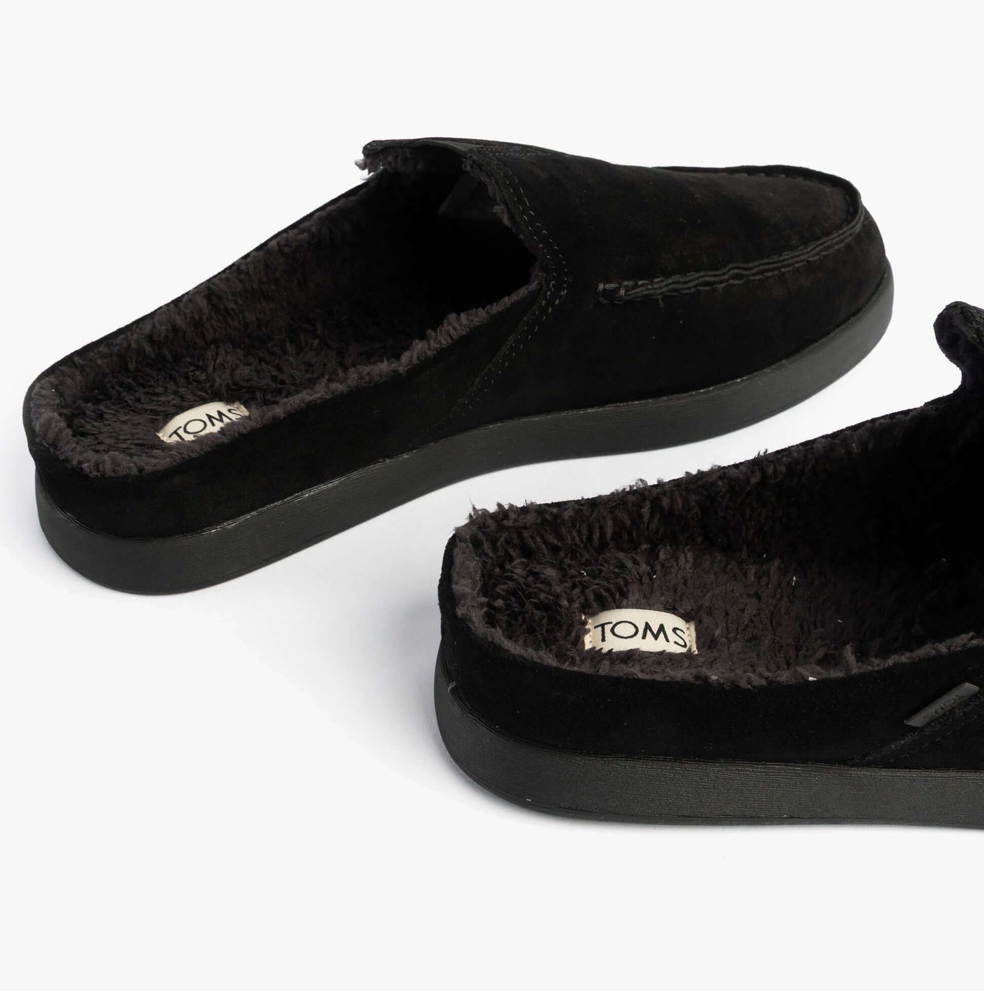 TOMS ALONSO MULE Mens Faux Shearling Lined Slippers Black side view showcasing soft interior shearling lining.