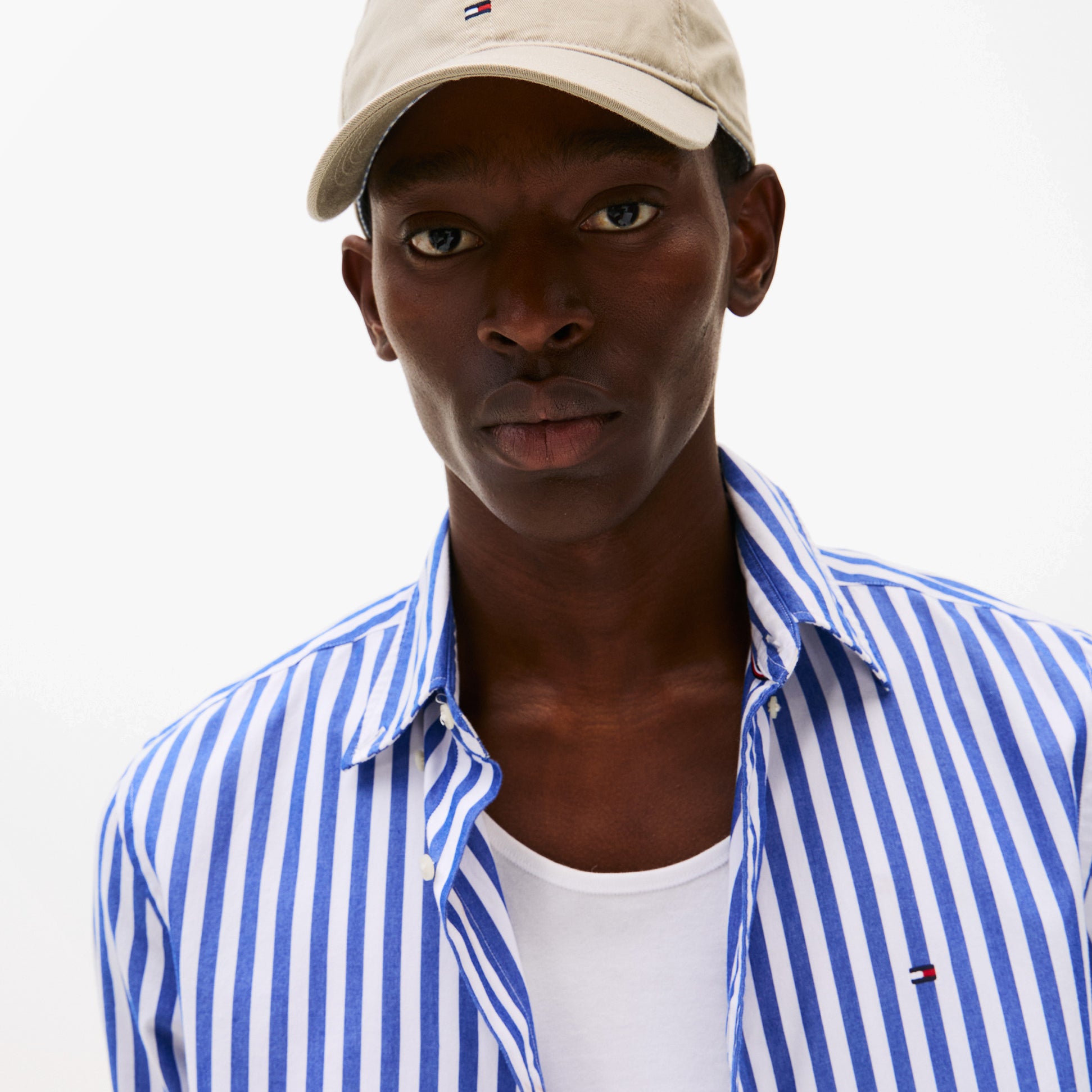 Tommy Hilfiger Flag Baseball Cap Sandalwood front view worn by model with striped shirt