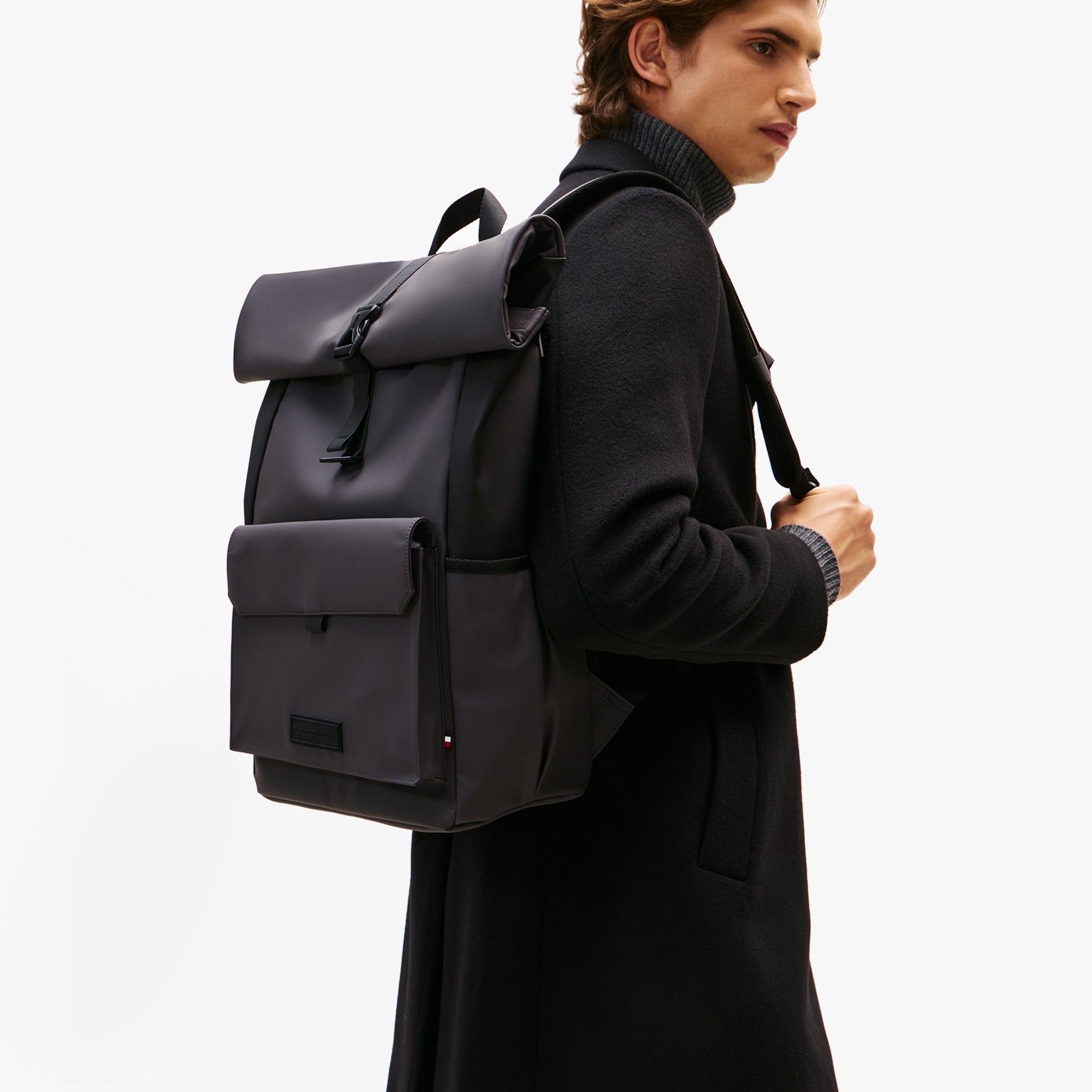 Tommy Hilfiger Mens Roll Top Backpack Charcoal Gray side view of model wearing backpack