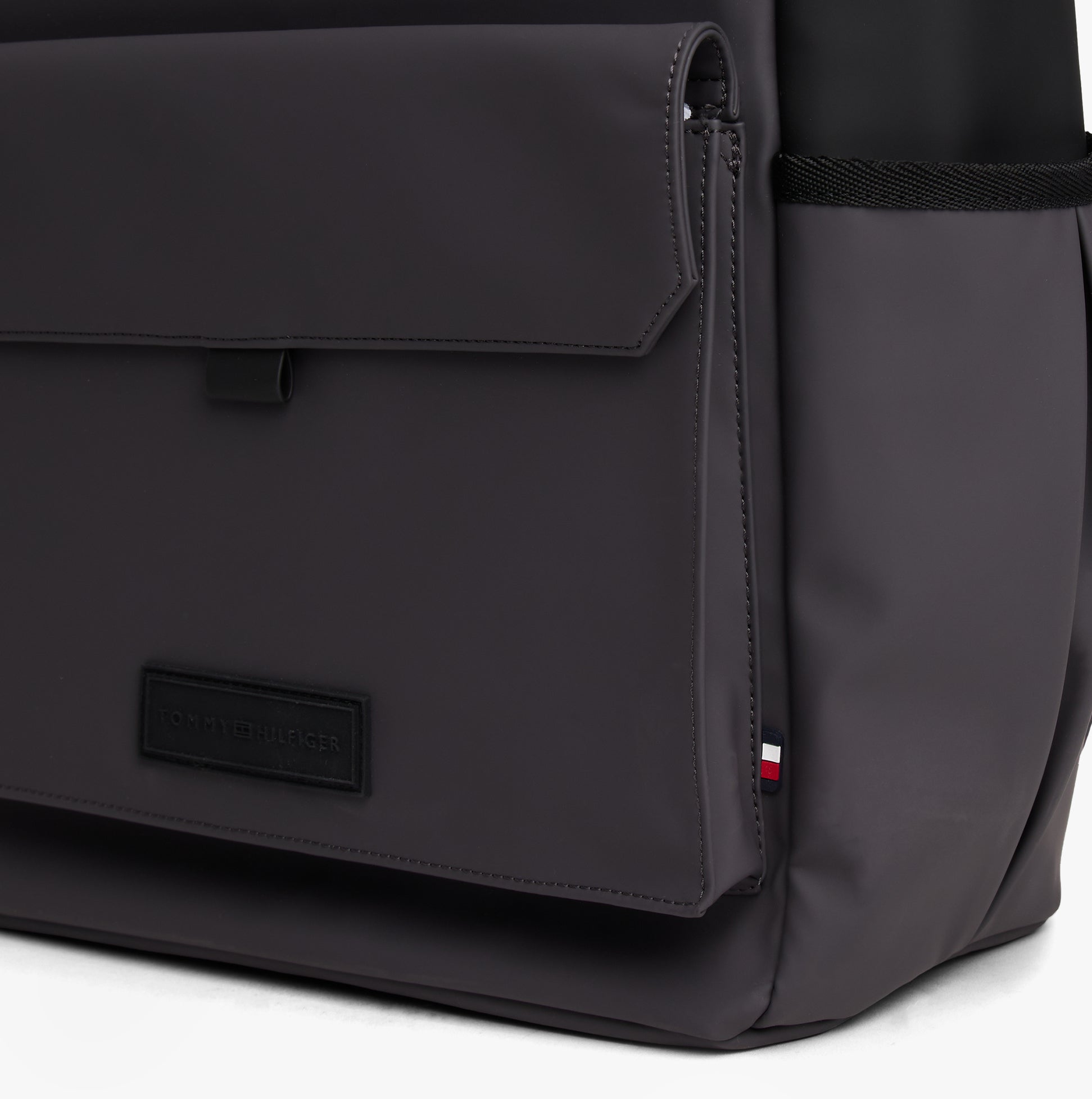 Tommy Hilfiger Mens Roll Top Backpack Charcoal Gray side view with buckle closure and detail on pocket.