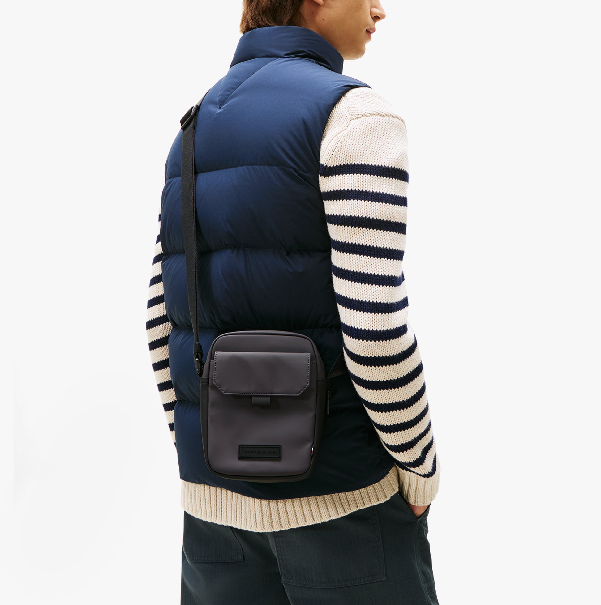 Tommy Hilfiger MINI REP Mens Crossbody Bag Charcoal Gray side view on model wearing navy vest and striped sweater