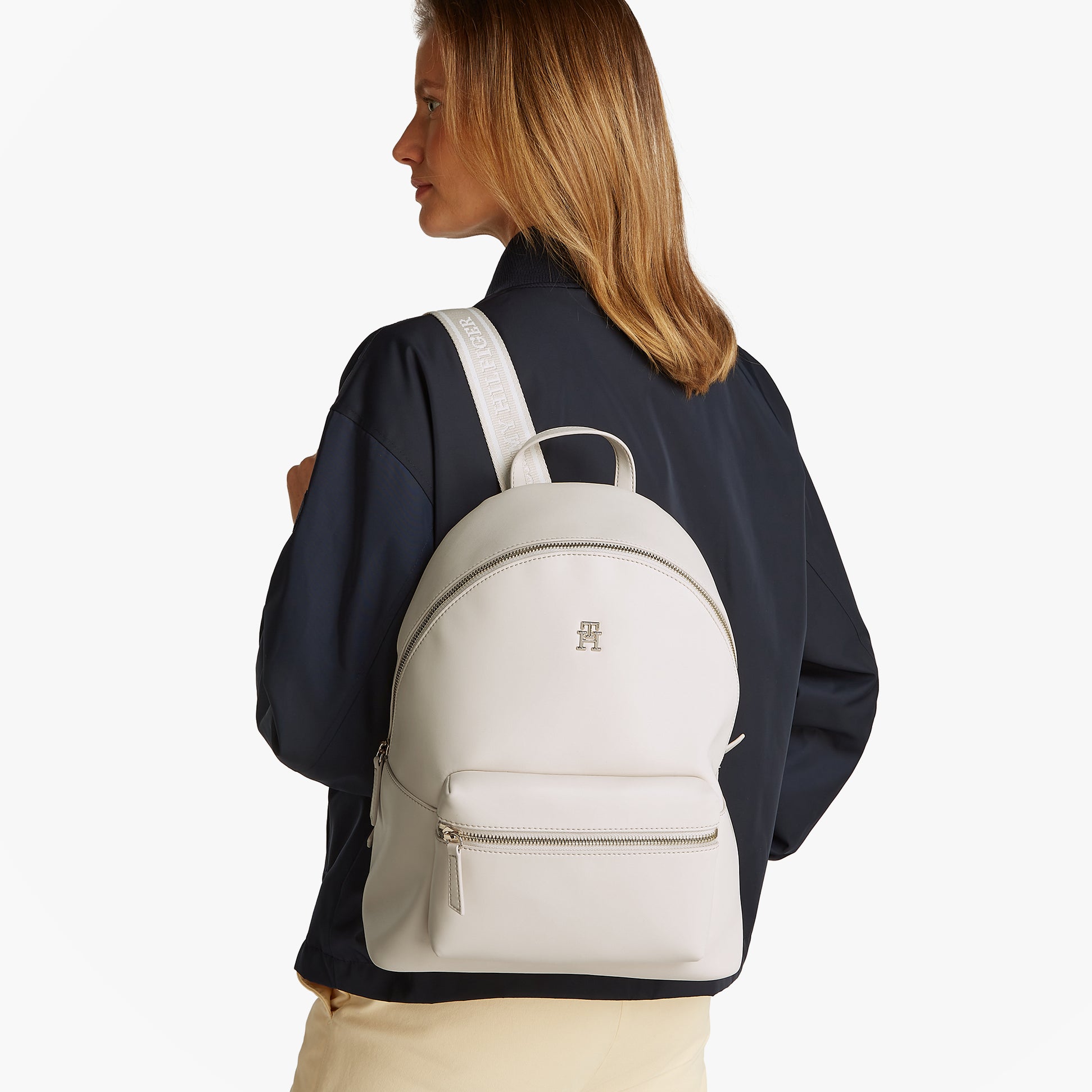 Tommy Hilfiger LOGOTAPE Womens Backpack Sugarcane side view on model with adjustable straps and TH monogram plaque.
