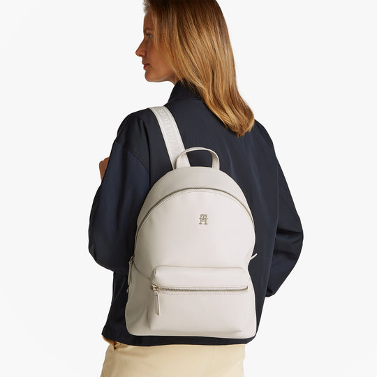 Tommy Hilfiger LOGOTAPE Womens Backpack Sugarcane side view on model with adjustable straps and TH monogram plaque.
