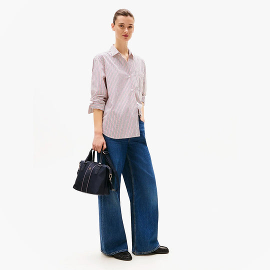 Tommy Hilfiger POPPY SMALL TOTE COR Womens Handbag Space Blue Corp side view held by a model with casual outfit.