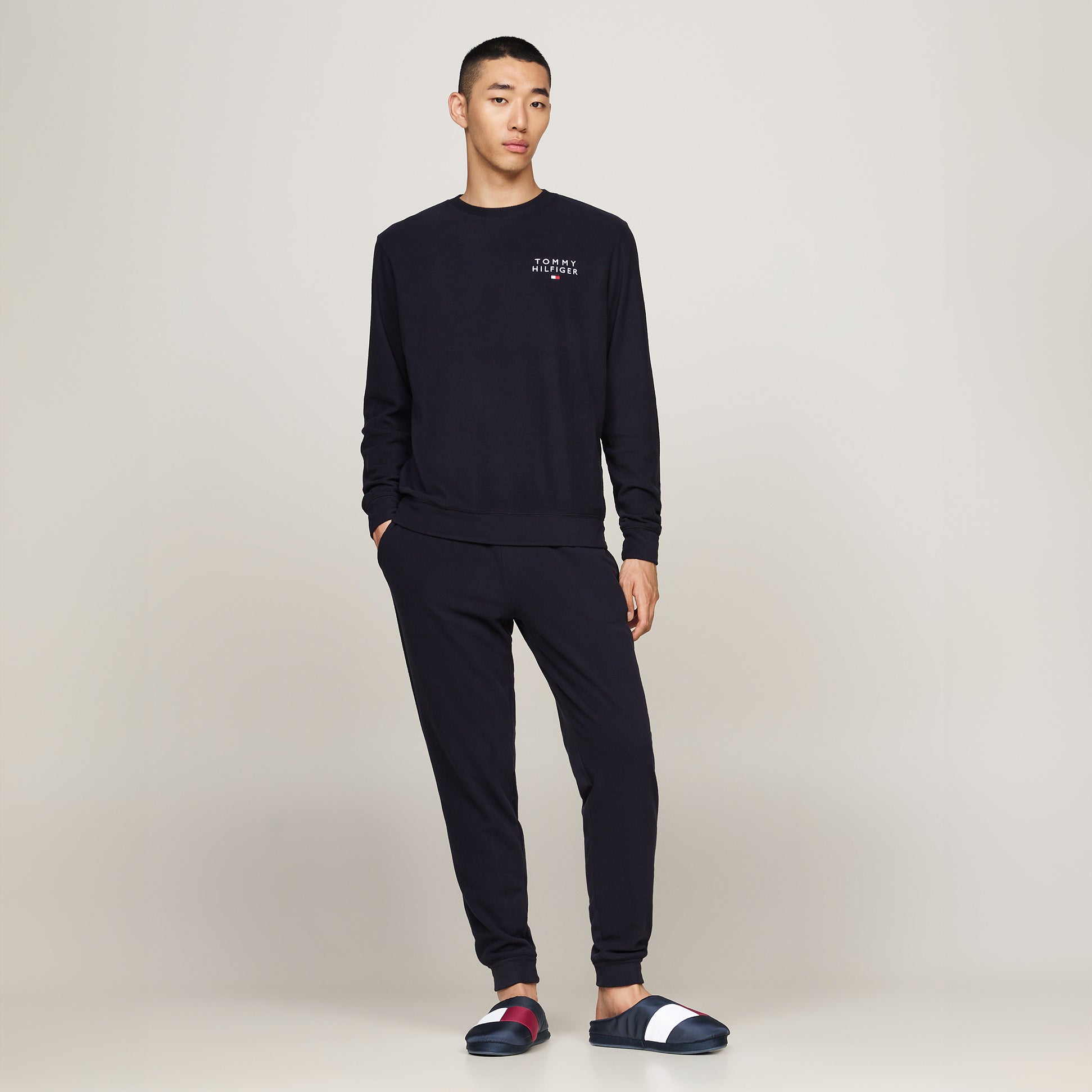 Tommy Hilfiger NYLON FLAG Mens Loafers Desert Sky side view with model wearing navy sweatshirt and pants.