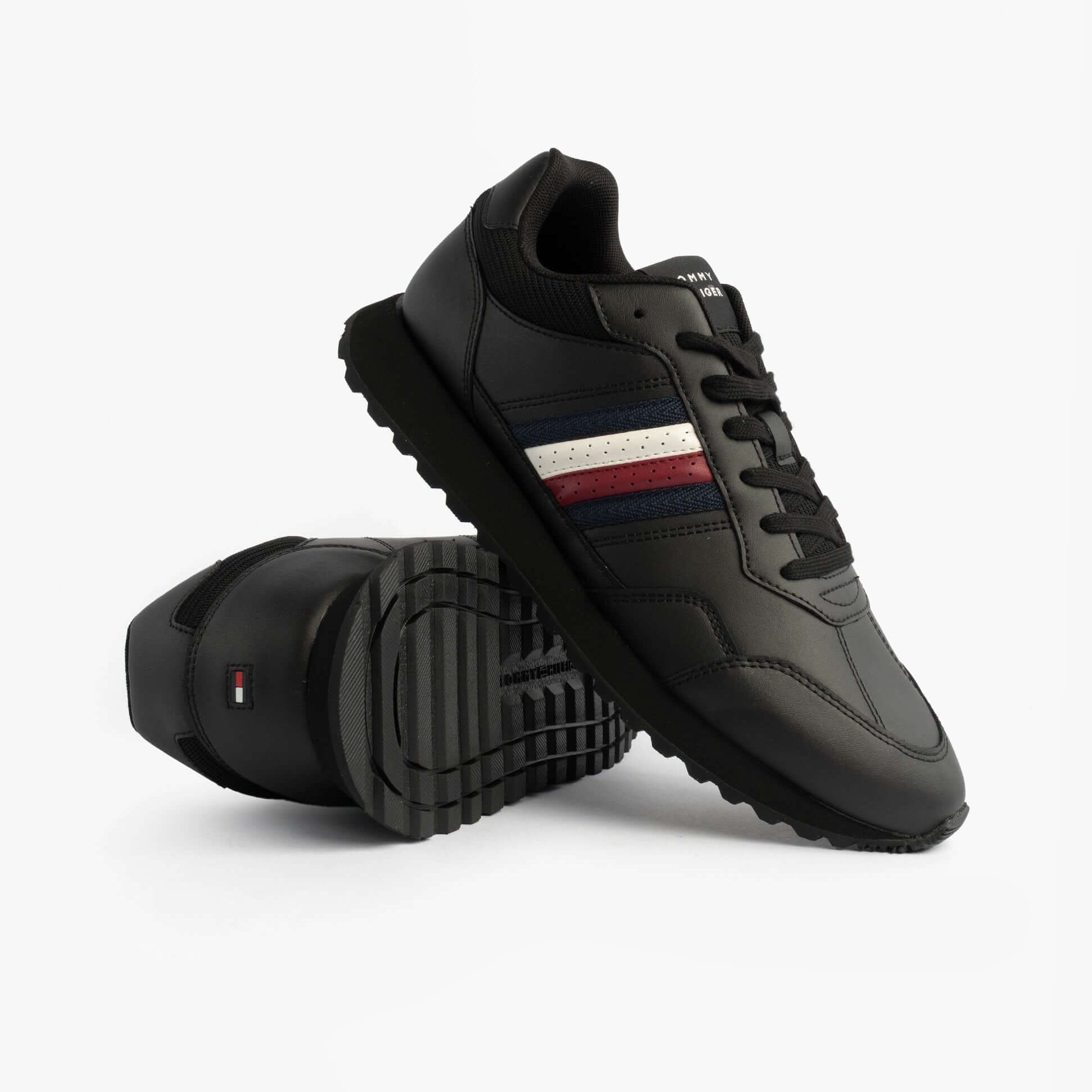 Tommy Hilfiger Mens Signature Tape Cleat Leather Trainers Black side view showcasing the sleek design and striped detailing.