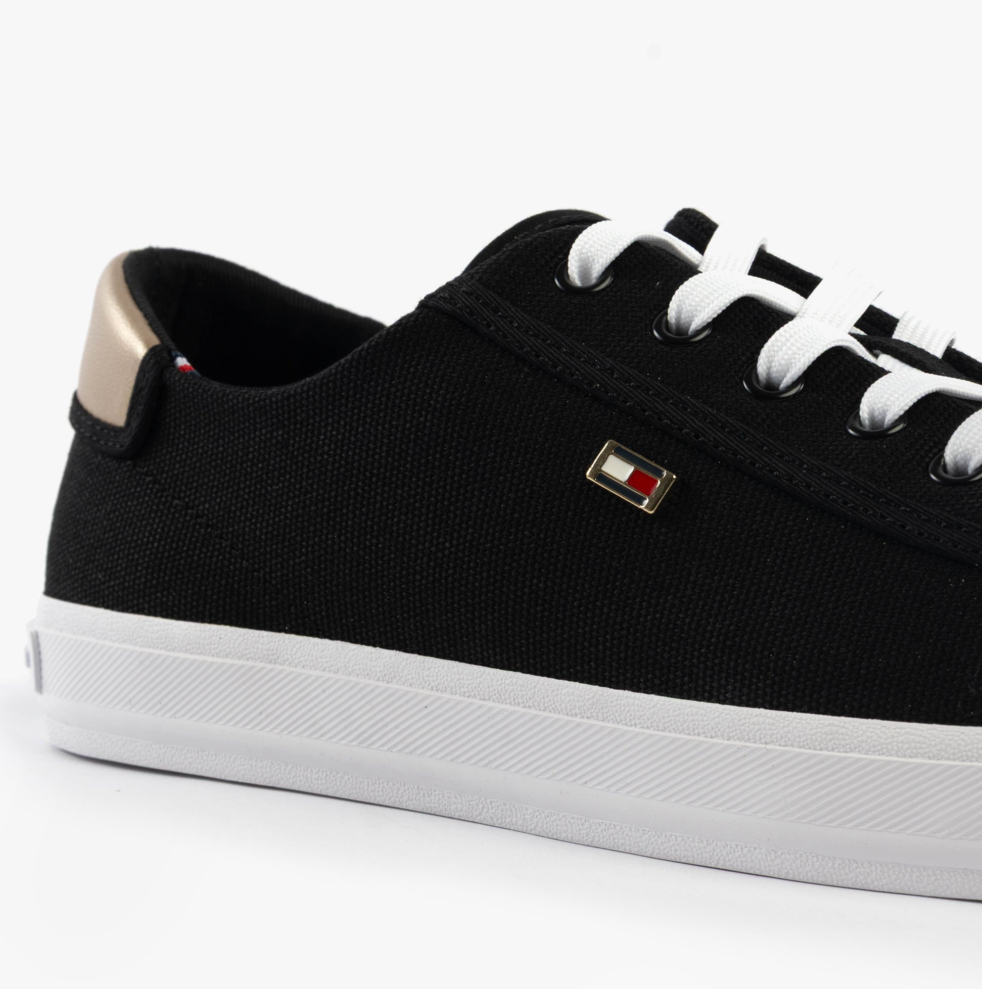 Tommy Hilfiger CANVAS METALLIC HEEL Womens Trainers Black side view with black canvas upper and gold accent.
