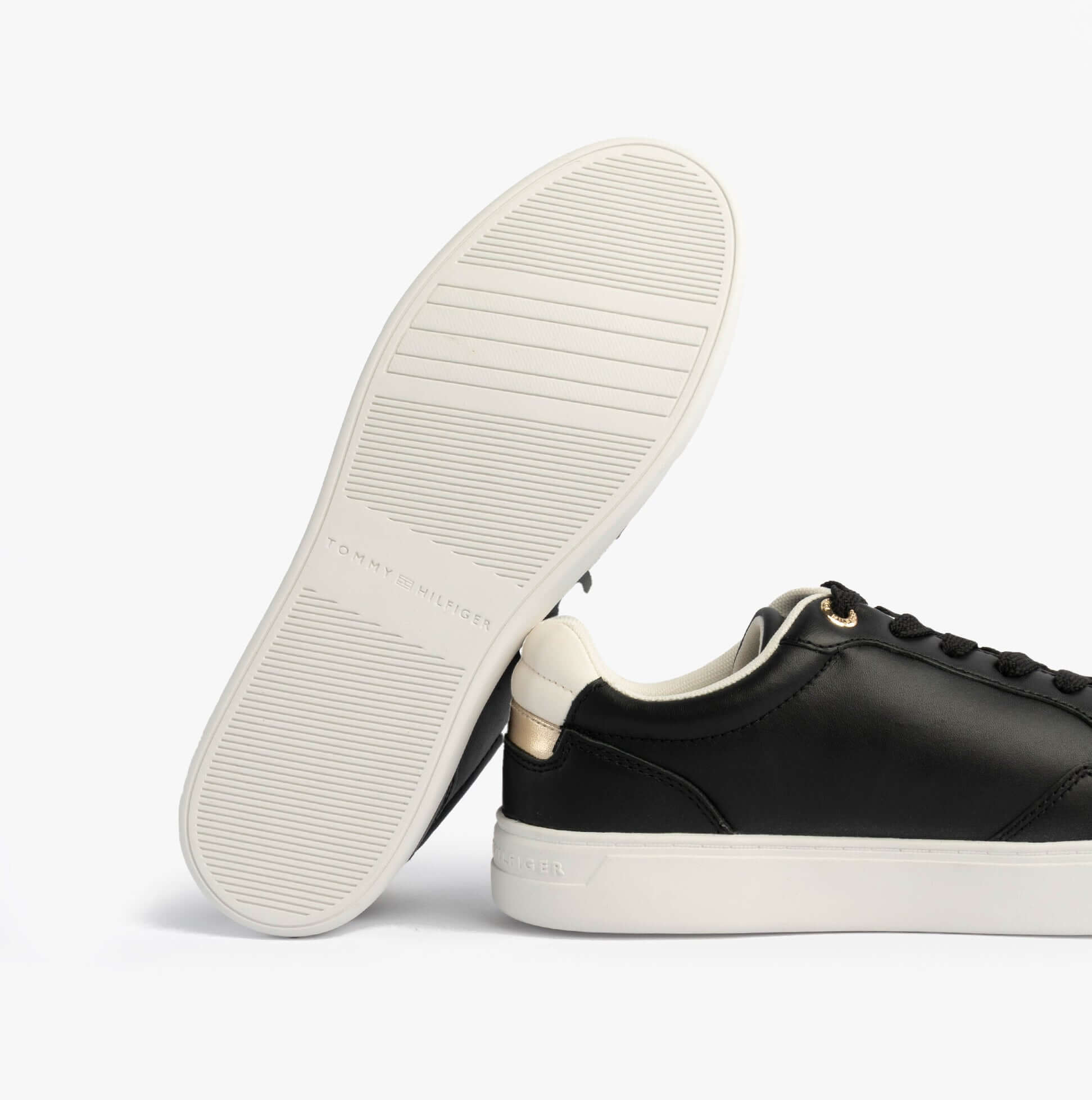Tommy Hilfiger Womens Leather TH Monogram Plaque Court Trainers Black bottom view with white sole and leather upper.