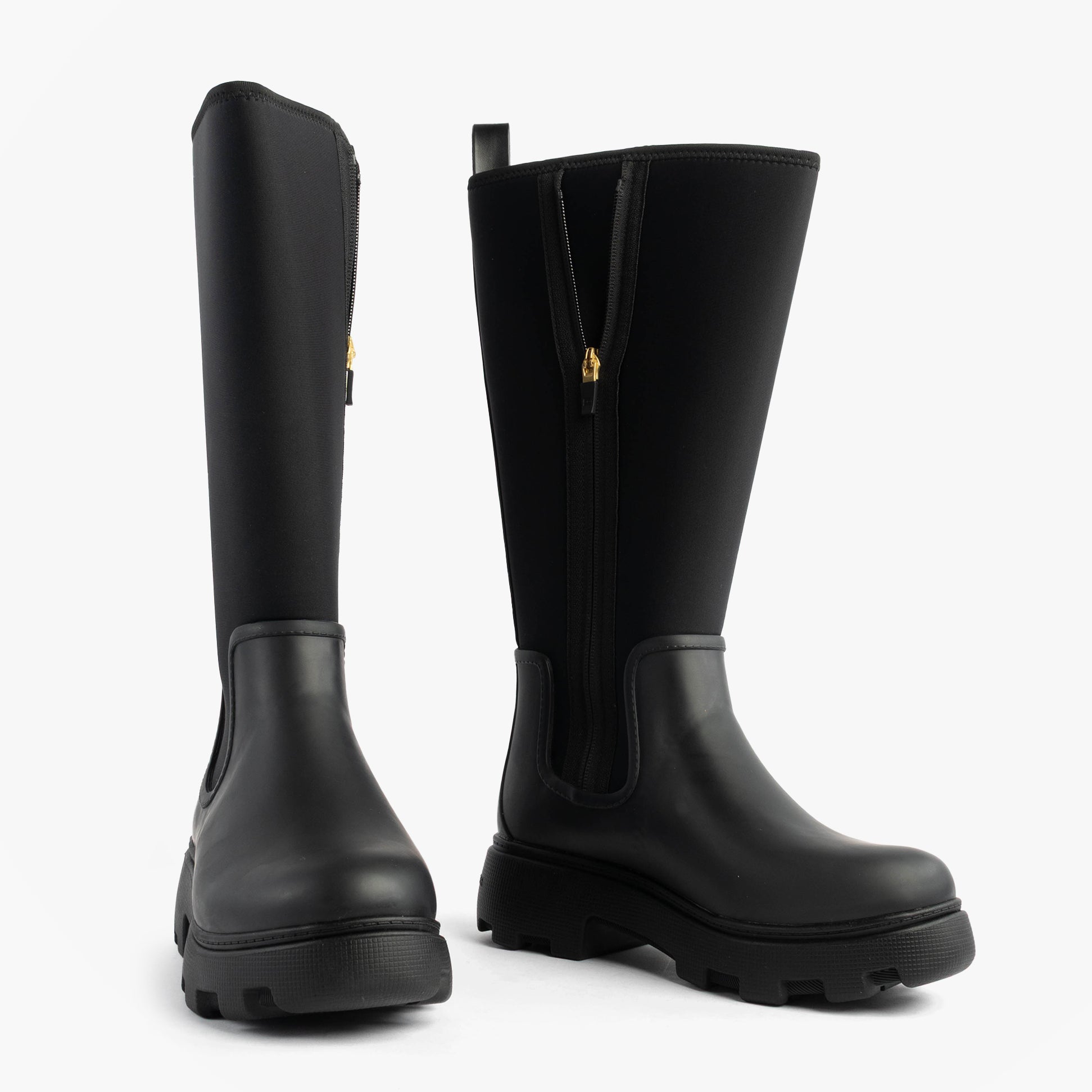 Tommy Hilfiger FLAG LONG RAINBOOT Womens Boots Black side and front view showcasing the rubber upper and chunky sole.