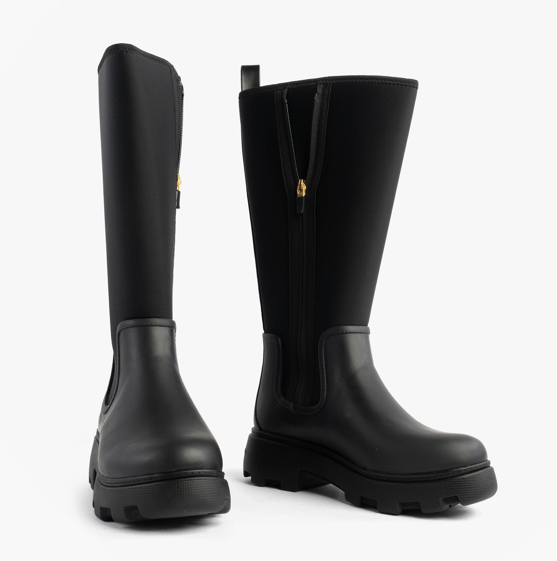 Tommy Hilfiger FLAG LONG RAINBOOT Womens Boots Black side and front view showcasing the rubber upper and chunky sole.