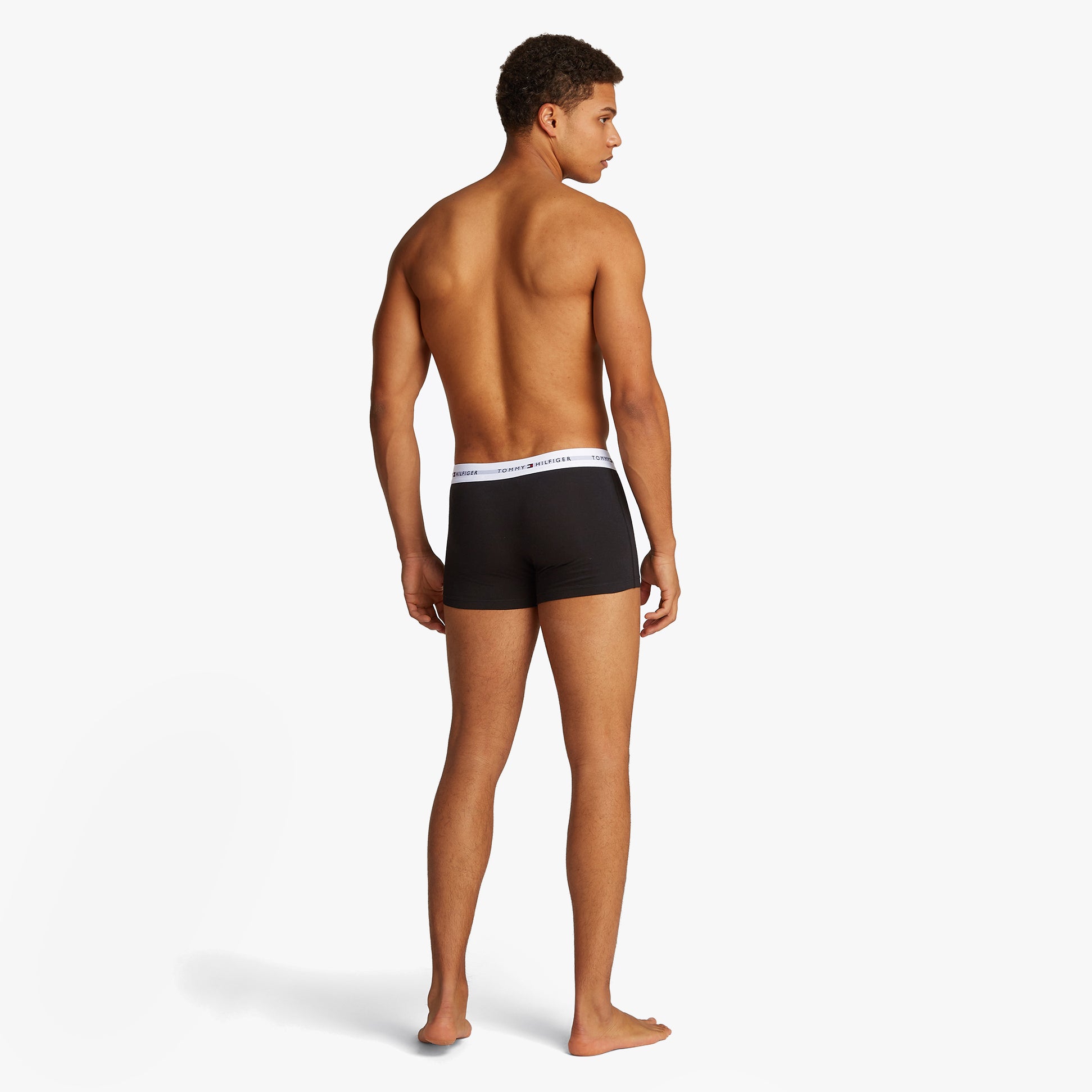 Tommy Hilfiger 3 Pack Mens Colour-Blocked Logo Trunks Black back view on model, showcasing elasticated waistband and trunk design.