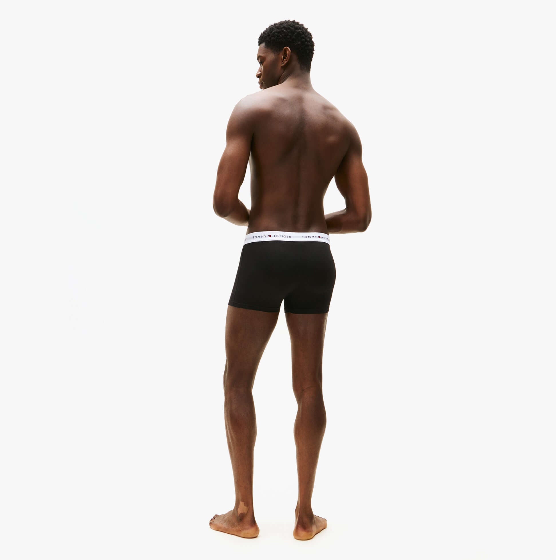 Tommy Hilfiger Mens 3 Pack Trunks Black, back view of a man wearing black trunks with branded waistband.