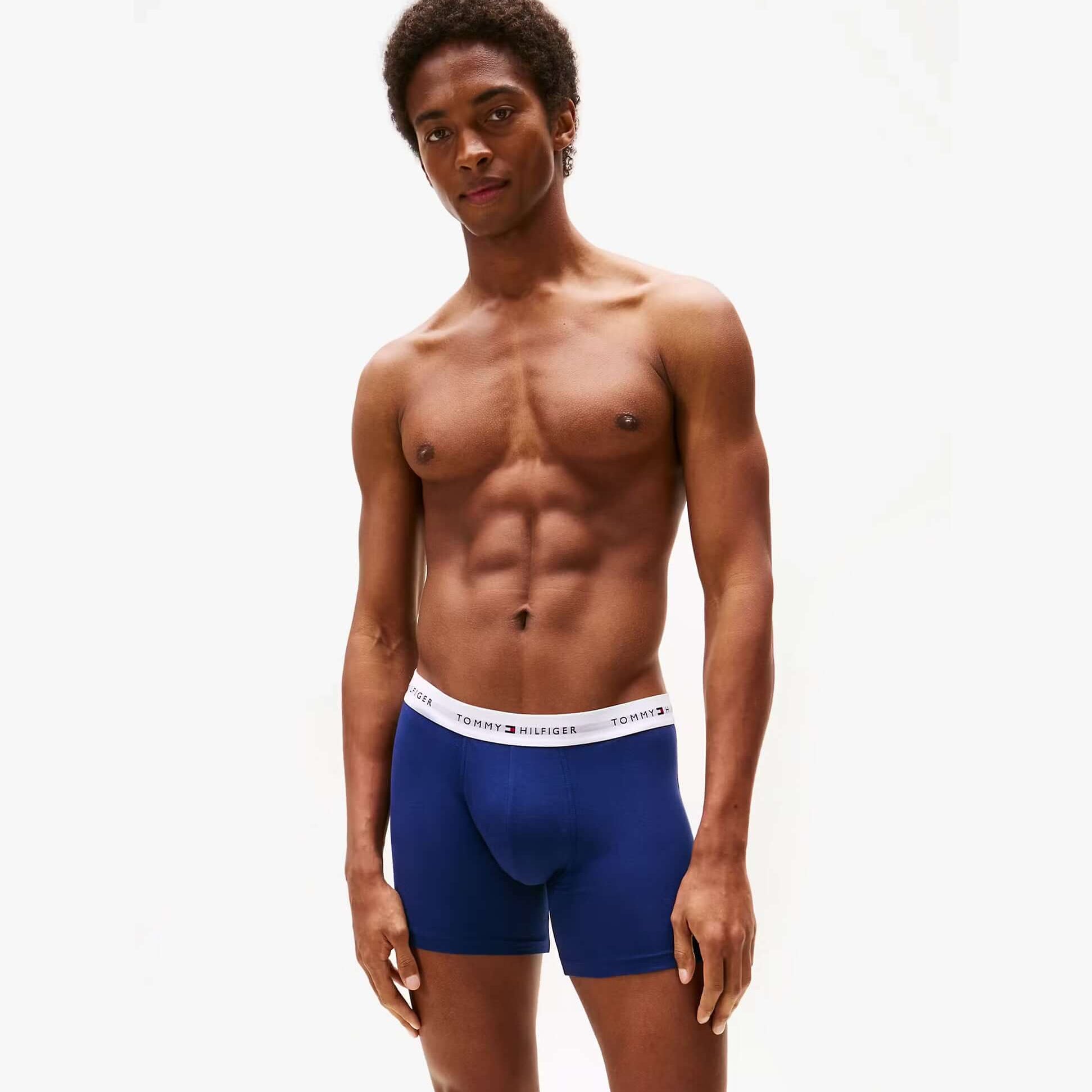 Tommy Hilfiger Mens 3 Pack Logo Waistband Boxer Briefs Multi side view model wearing navy blue boxer briefs with logo waistband.