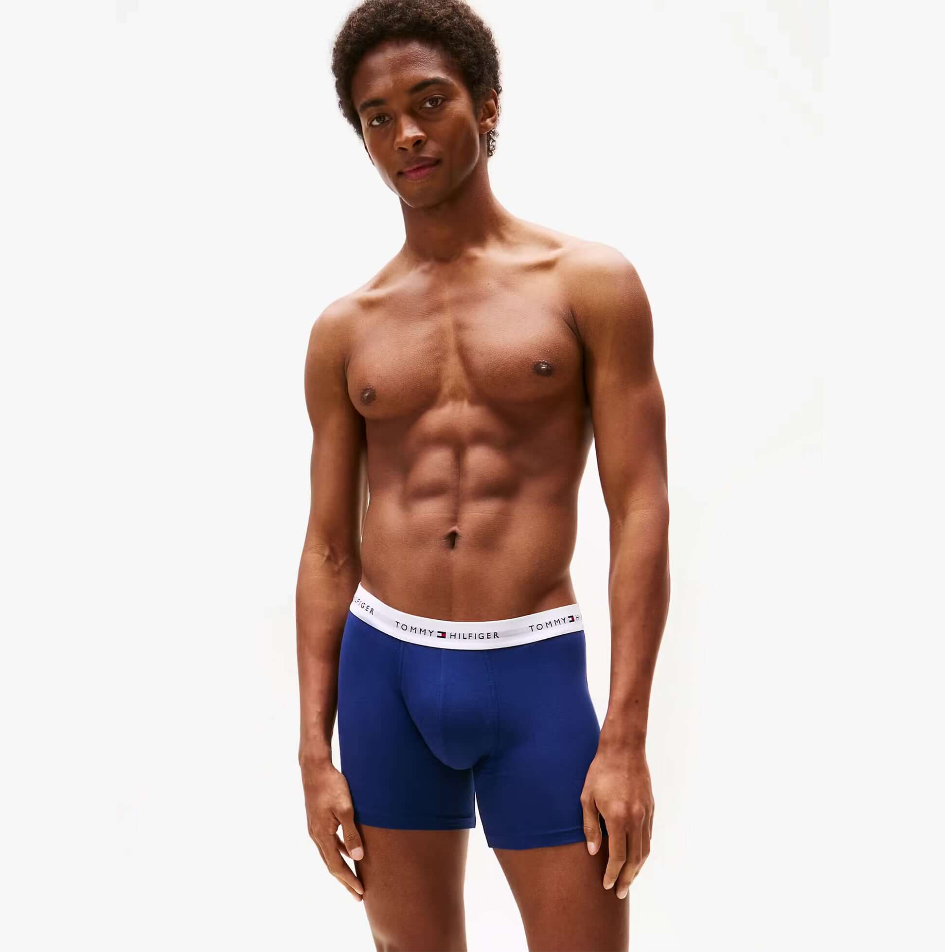 Tommy Hilfiger Mens 3 Pack Logo Waistband Boxer Briefs Multi side view model wearing navy blue boxer briefs with logo waistband.