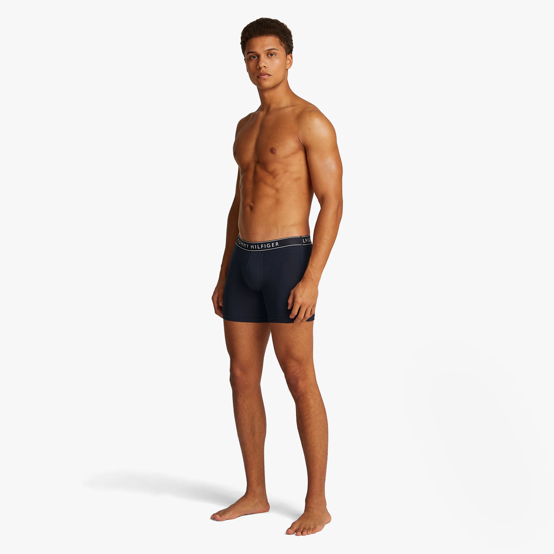 Tommy Hilfiger 3 Pack Mens Trunks Desert Sky side view on model wearing, showcasing the elasticated waistband and trunk fit.